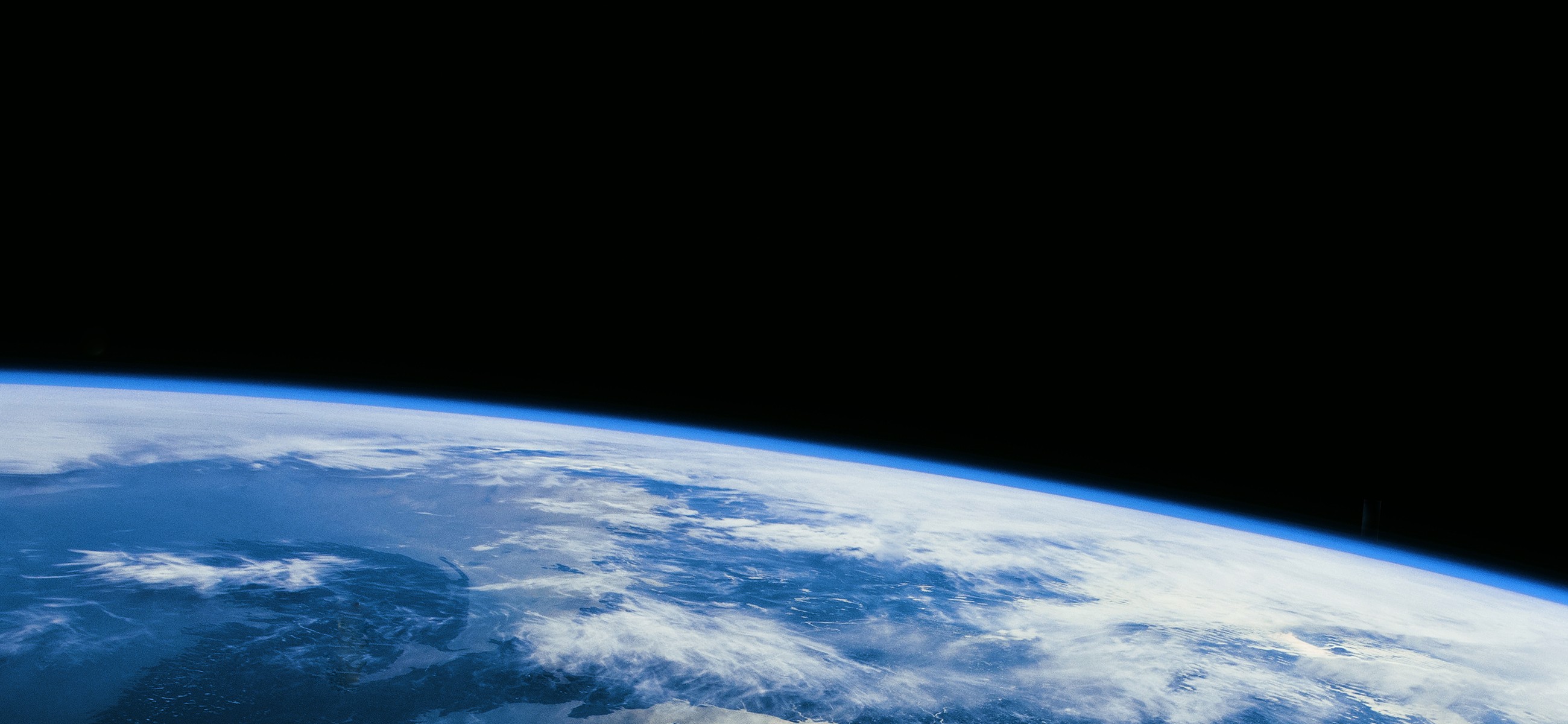 Stunning view of Earth from space, showcasing the planet's blue oceans and white clouds against the darkness of space.